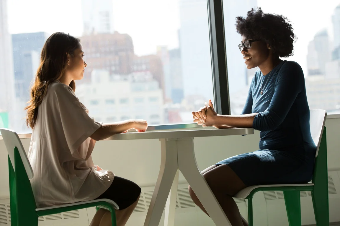 2 Women Sat At table