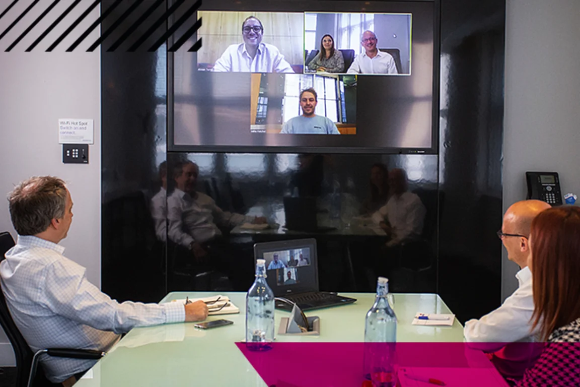 A hybrid meeting taking place in a state of the art AV conference room at Broadway House.