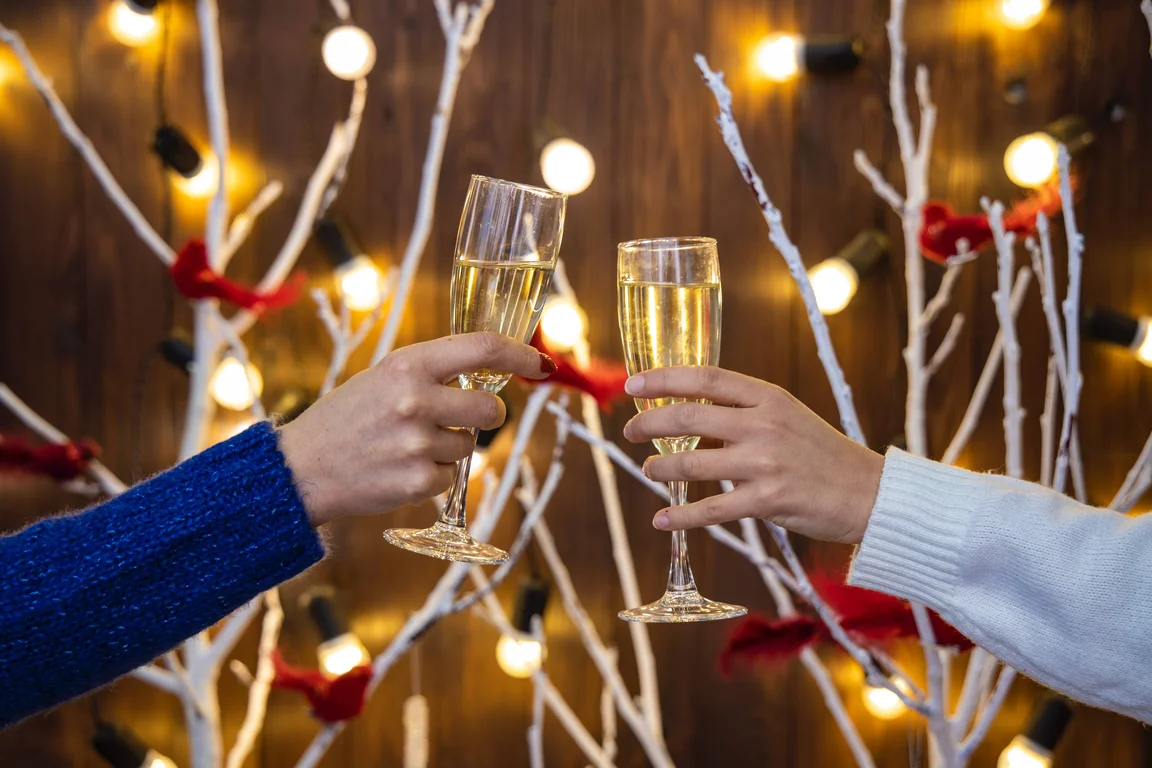 2 people raising champagne flute glasses at Christmas 