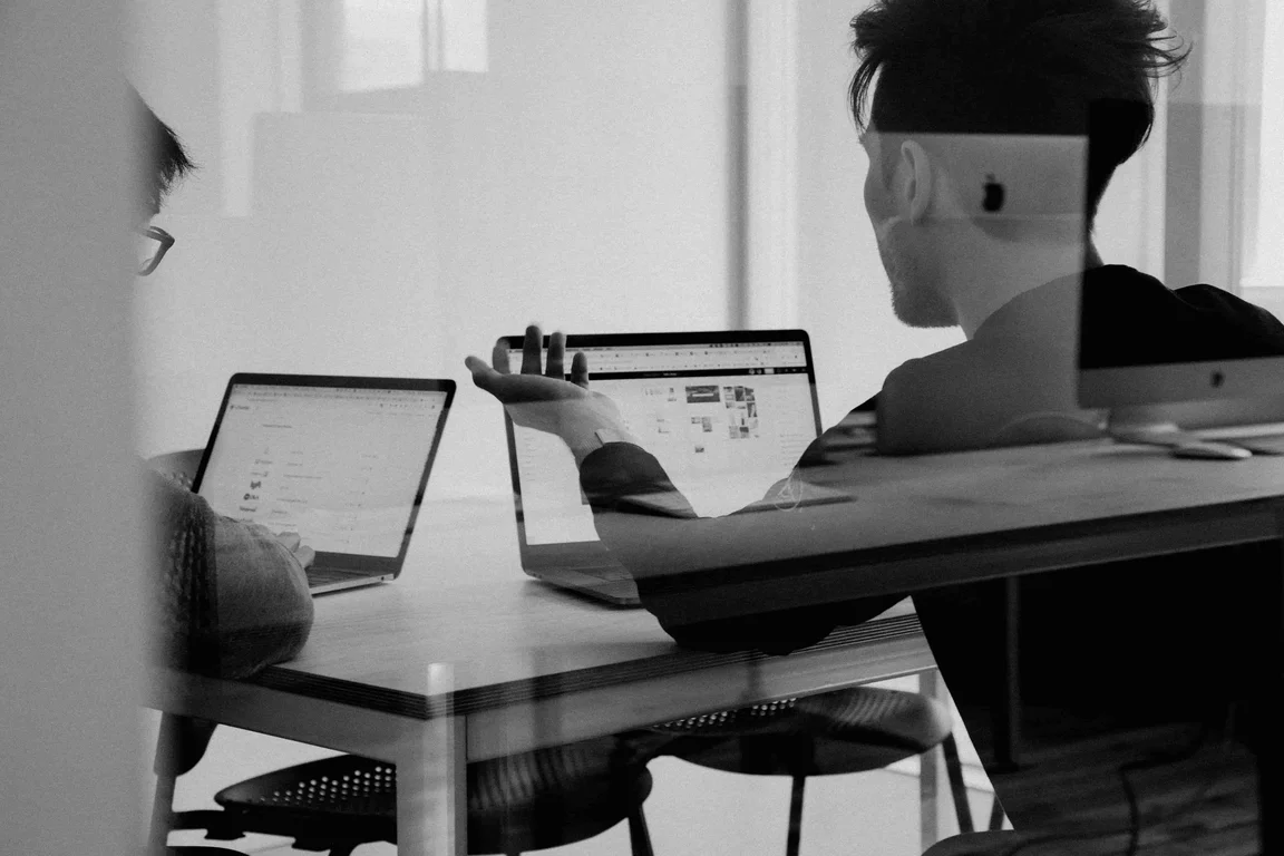 people sat in a meeting room for an event in front of computers