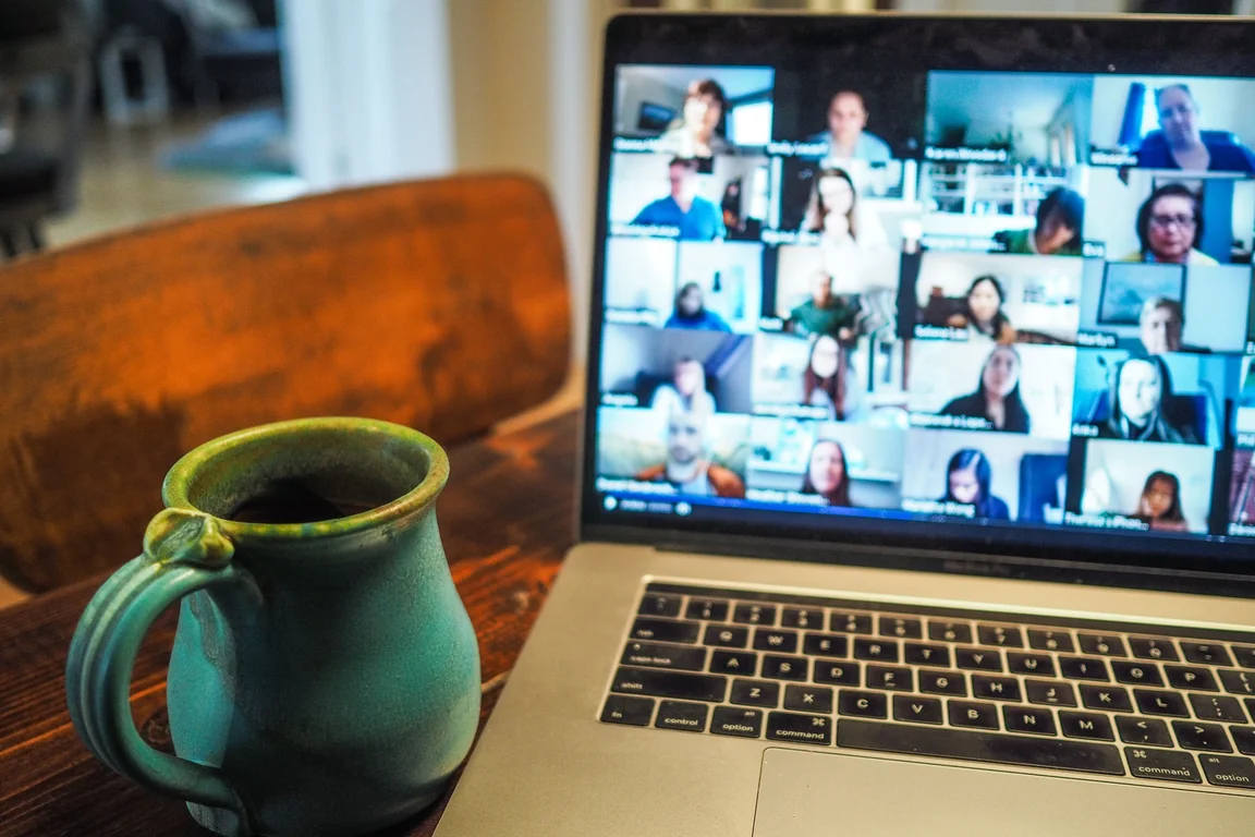 hybrid team meeting on laptop with a coffee mug