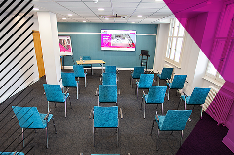 Small seminar room with chairs facing an interactive board.