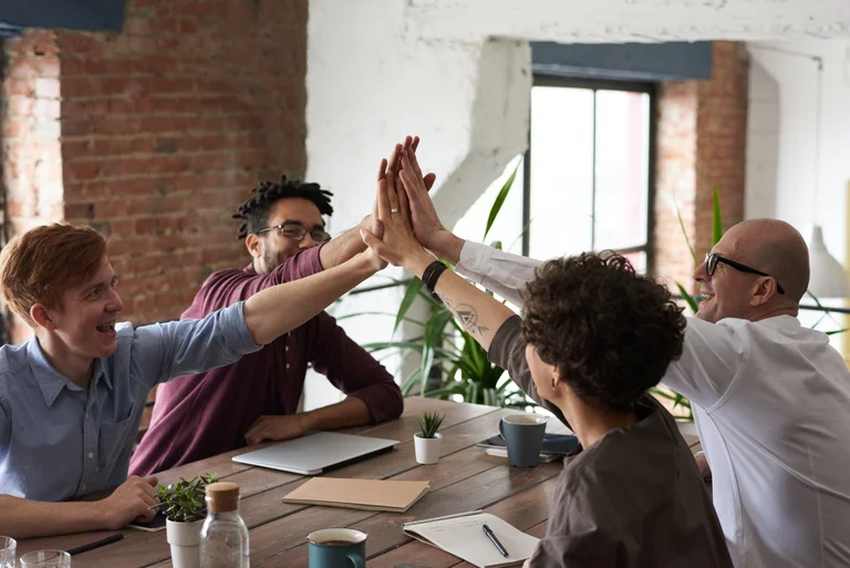 group of people doing a high 5 with hands