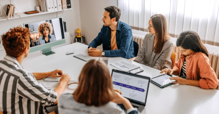 Team participating in a hybrid meeting with colleagues.