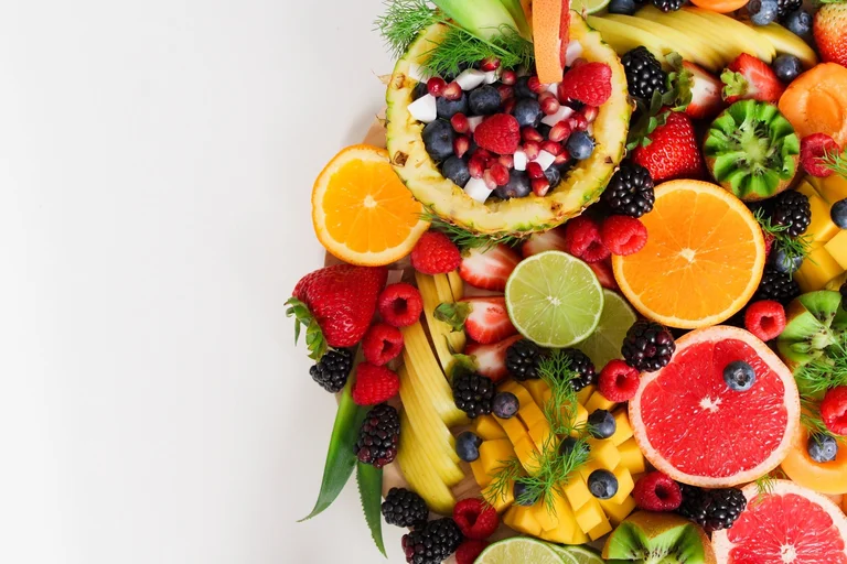 Different types of fruit arranged in a display, photographed from above.